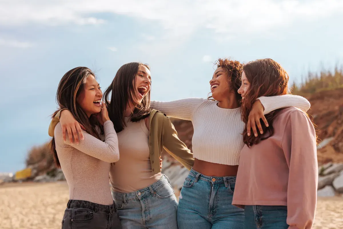 Four women laughing together outdoors